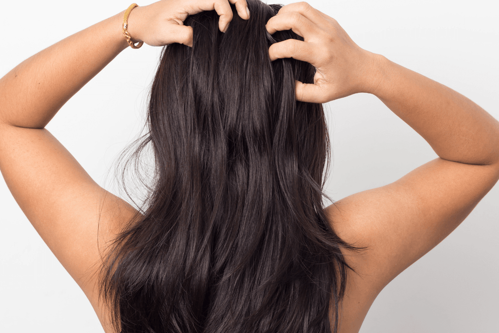 woman with brunette hair hands on scalp