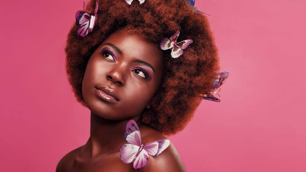 woman with afro pink background and butterflies