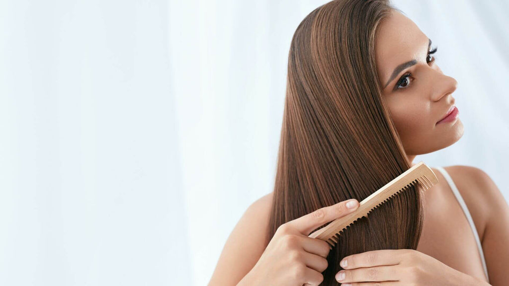 woman with straight hair combing it