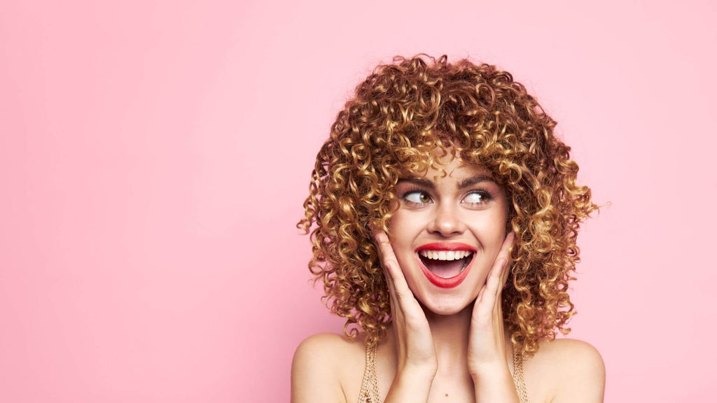 woman with curly hair hands on mouth