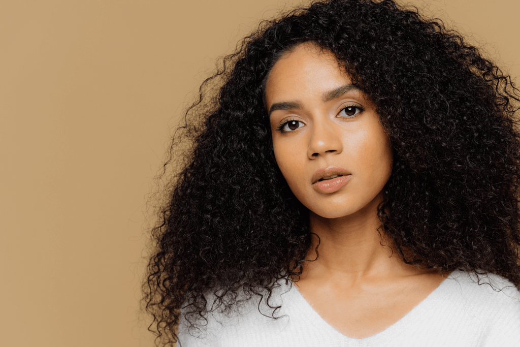 woman with curly hair yellow background