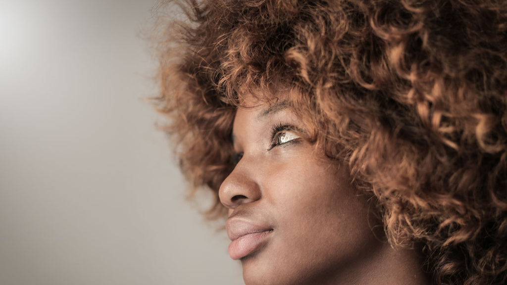 woman with curly hair grey background