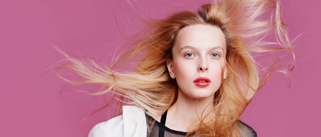 woman with blonde hair pink background