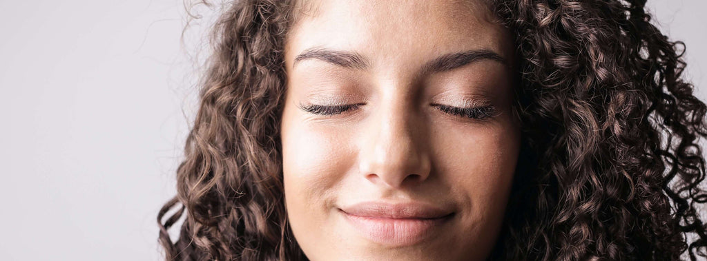 woman with curly hair eyes closed