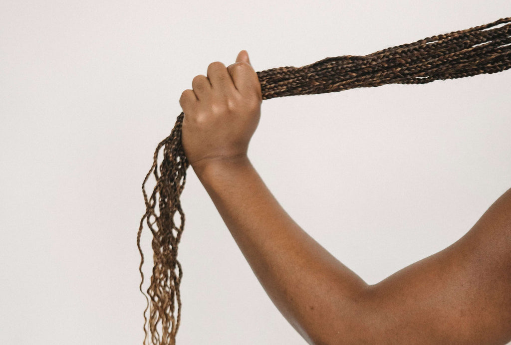 woman with long braided hair in hand