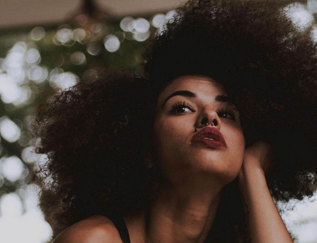 woman with curly hair looking up