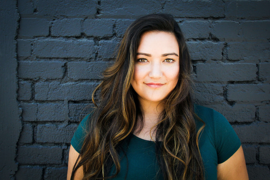 woman with dark ombre hair brick wall 