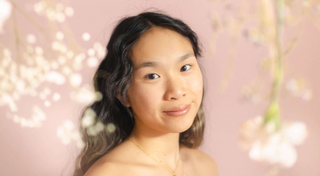 woman with brunette hair pink background