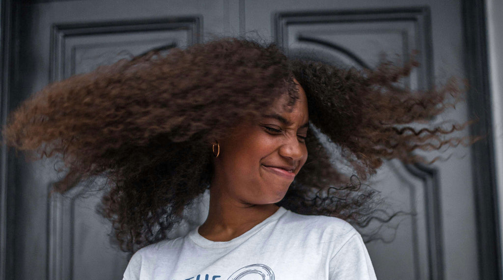 woman with curly hair in air 