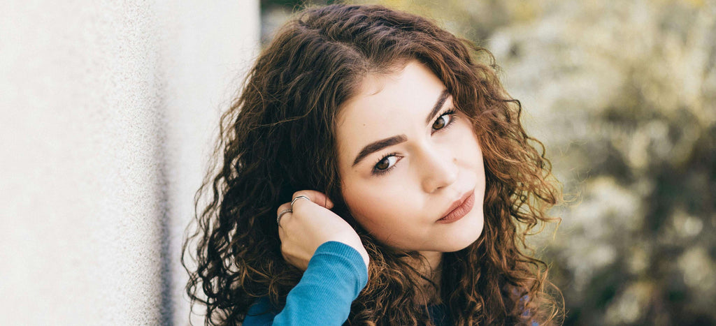 woman with curly hair looking over shoulder