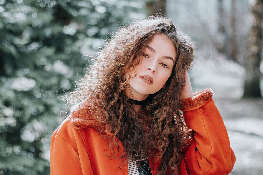 woman with curly red hair red jacket