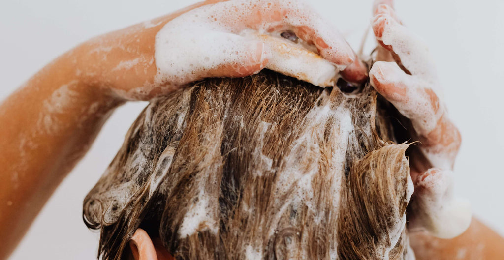 woman with hands in hair shower