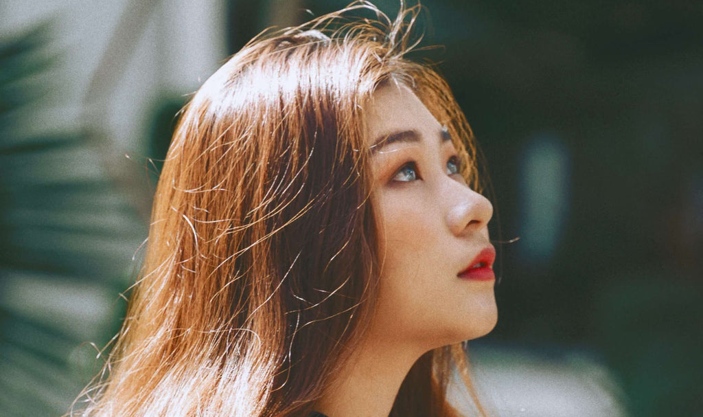 woman with shiny red hair looking up