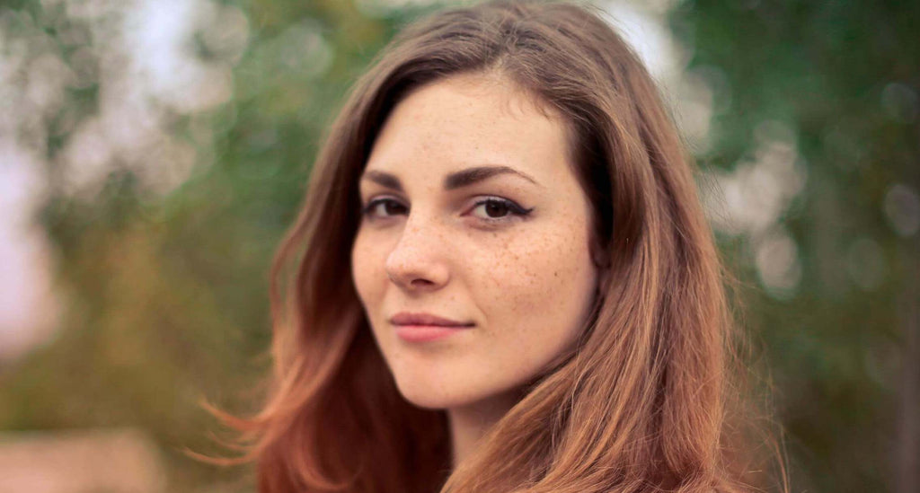 woman with brunette hair trees in background