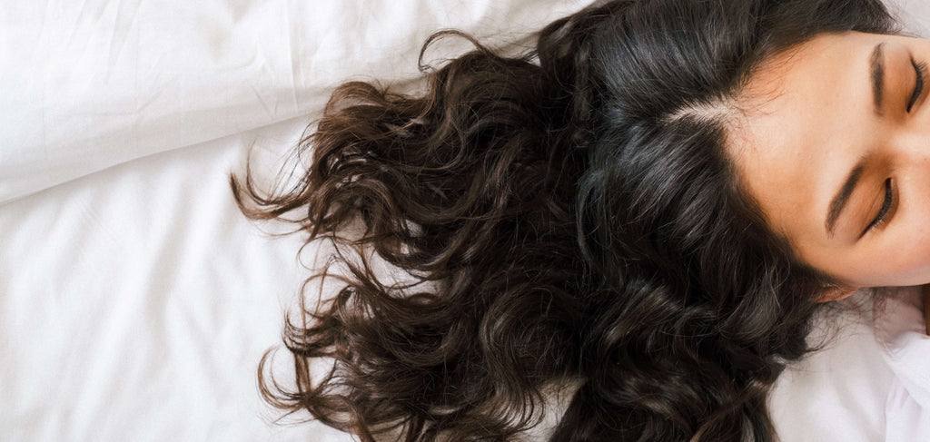 woman brunette hair on white sheets