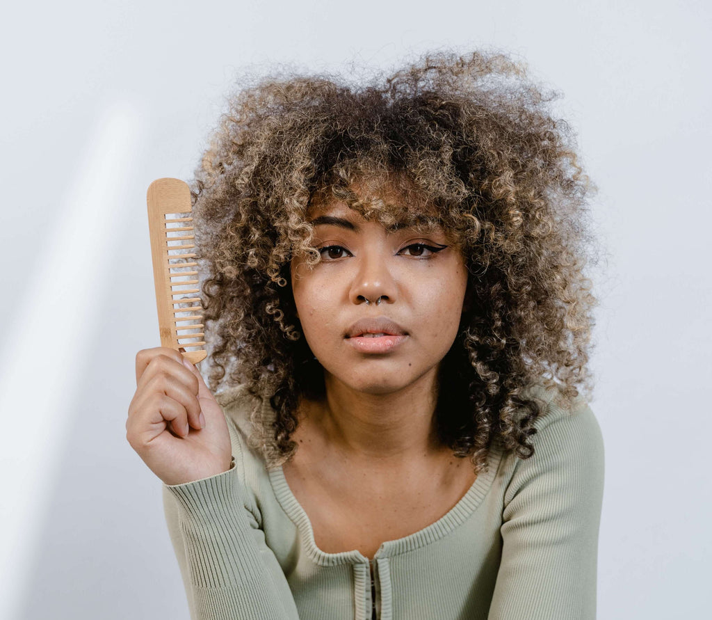 woman holding comb curly hair